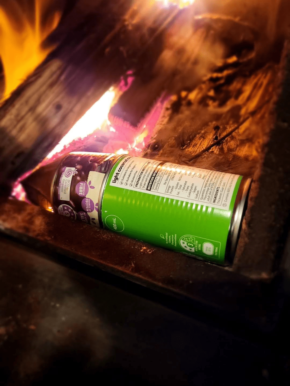 Tin can biochar kiln in action with flames visible